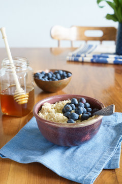 Oats porridge served with blueberries and honey. Selective focus.