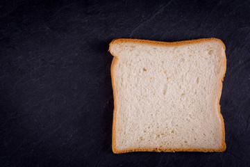 slice of toast bread on dark slate background