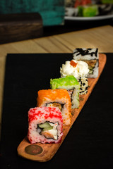 Traditional japanese food, various kinds of sushi on wooden board