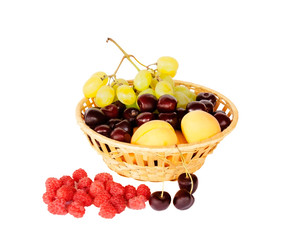 Bright summer fruits in basket isolated on white