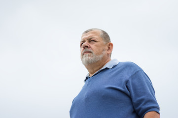 Obraz premium Outdoor portrait of a bearded senior man looking with hope