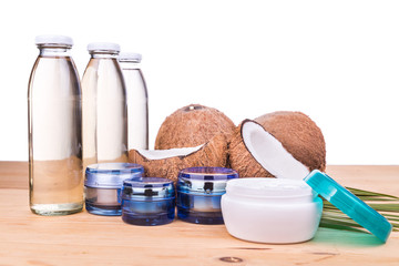Extra virgin coconut oil in bottles and coconut processed oil in skincare jars with coconut fruits as background