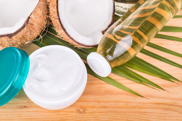 Extra virgin coconut oil in bottles and coconut processed oil in skincare jars with coconut fruits as background
