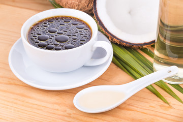 Closeup of bulletproof coffee with cold pressed extra virgin coconut oil on wooden table, part of ketogenic diet