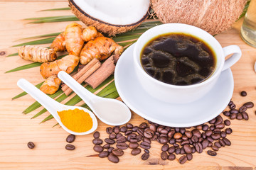 Bulletproof coffee blended with cold pressed extra virgin coconut oil, turmeric and clove on wooden table, healthy ketogenic diet