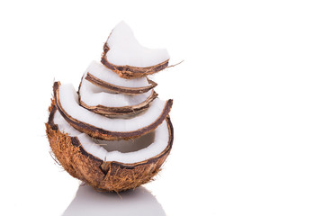 Old brown organic coconut fruit broken into pieces and stacked