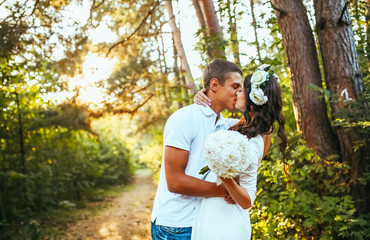 A young couple kiss in park at sunrise. Closeup