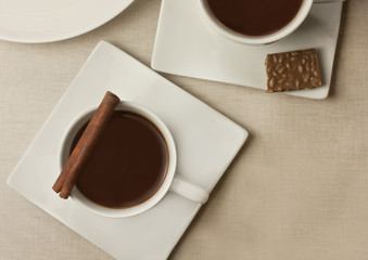 Two cups of dark hot chocolate with cinnamon stick