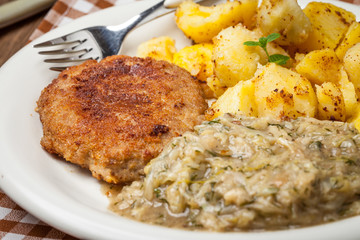 Delicious meal of minced meat cutlet, potatoes and fried cabbage