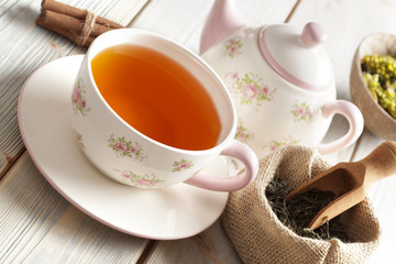 Cup of tea and teapot on wooden table