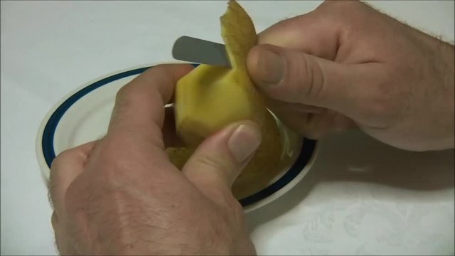 hands peeling a potato
