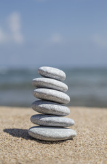 Fototapeta na wymiar stack of pebble stones on balance on sand