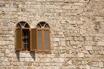 two arch windows on a stone wall