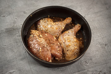 Raw chicken meat in marinade in frying pan ready for cooking