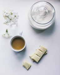 Obraz na płótnie Canvas cup of coffee with milk, sugar, white chocolate, flowers on a white background
