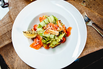 Caesar salad with salmon, croutons, Parmesan cheese and cherry tomatoes