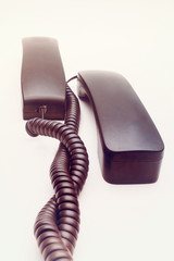 Telephone receiver with cable on white background