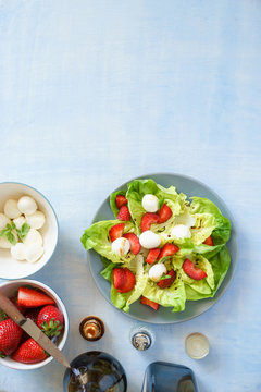 Green butterhead lettuce salad with baby mozzarella and strawberries