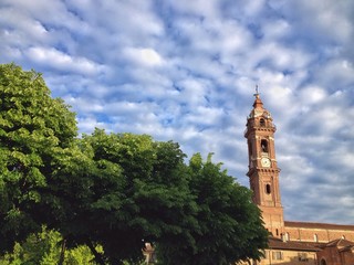 Fototapeta na wymiar cielo pieno di nuvolette sopra il campanile