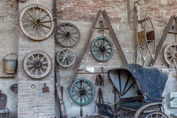 Fototapeta na wymiar Hanging wheels in a farm and an old curricle