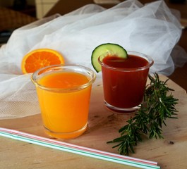 Two glasses of fresh smoothie with tomato and orange 