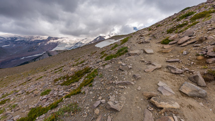 Rocky slopes in the mountains. Amazing view at the peaks which rose against the cloud sky. Path on the tops of mountains. BURROUGHS MOUNTAIN TRAIL, Sunrise Area, Mount Rainier National Park