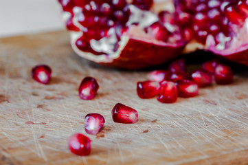 Ripe pomegranate seeds on wooden background