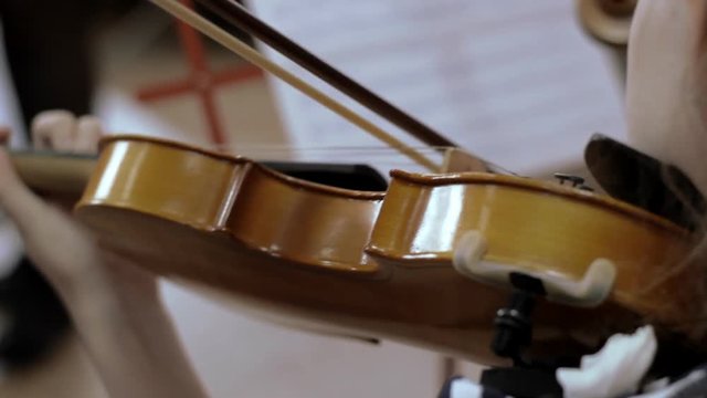 child plays on a violin. close-up