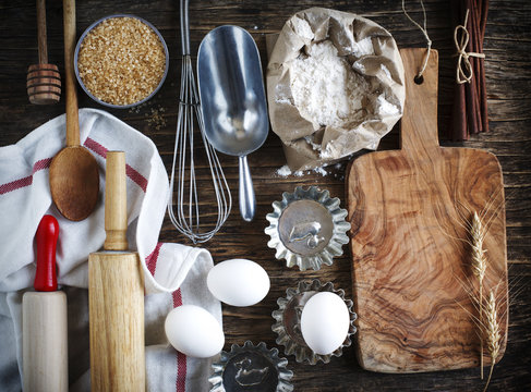Vintage kitchen utensils, props and ingredients on a rustic wood
