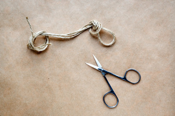 concept scissors cut knot on rope at background kraft paper