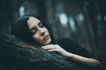 Fototapeta na wymiar Portrait of a beautiful mysterious woman in the forest. Cold ton