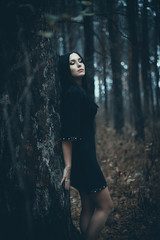 Portrait of a beautiful mysterious woman in the forest. Cold ton