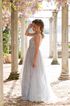 young bride in a wedding dress poses on the terrace