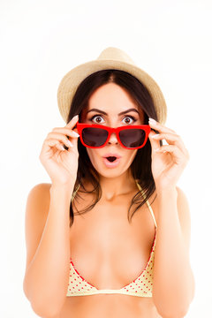 Portrait of shocked pretty woman in bikini, hat and glasses