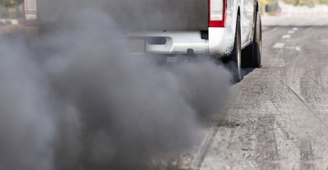 Obraz premium Air pollution from vehicle exhaust pipe on road