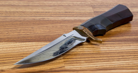 Beautiful hunting knife against wooden background