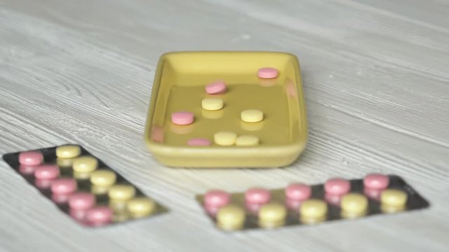 Tablets fall in the container mounted on the table