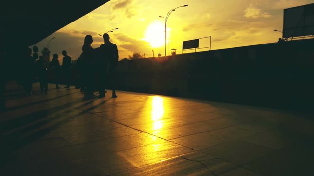 People silhouettes at sunset on the station