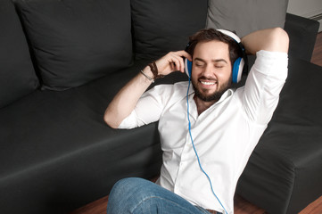 Obraz premium Man on a couch in headphone listen to music 
