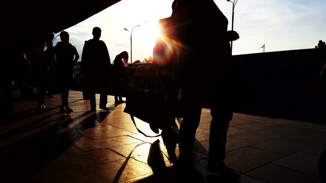 People silhouettes at sunset on the station