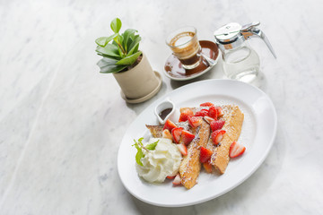 French toasts  strawberries and syrup with vanilla ice cream. 