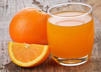 Orange juice and orange on wooden background