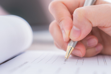 Hand with pen over application form..