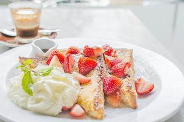 French toasts  strawberries and syrup with vanilla ice cream. 