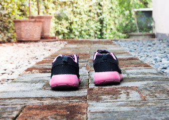 Running shoes in home garden foot path