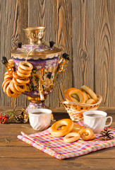 Samovar on a wooden background with bagels and tea