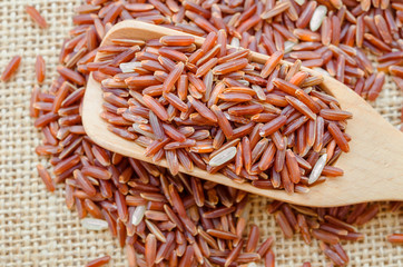 brown rice in a wooden spoon.