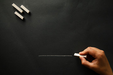 Hand with chalk on board