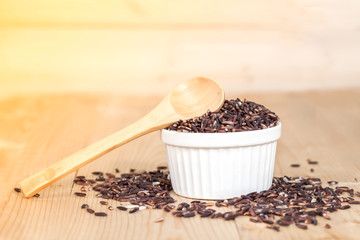 Rice berry in bowl on wood background