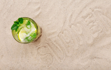 Fototapeta na wymiar Summer cocktail with lime and mint on the beach
